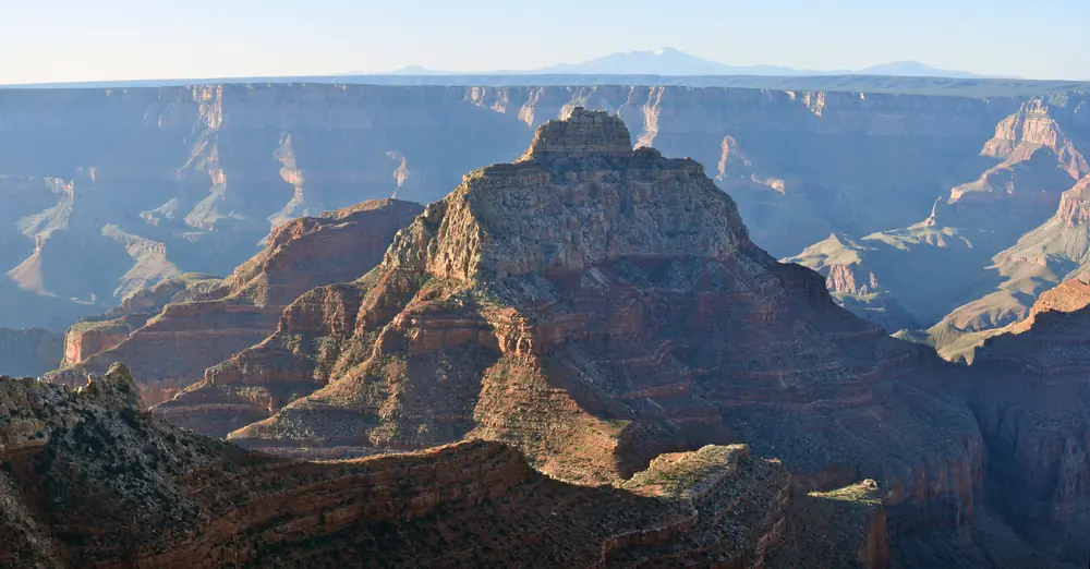 Sunrise light over canyon buttes seen from Angel's Window Overlook on the North Rim of the Grand Canyon