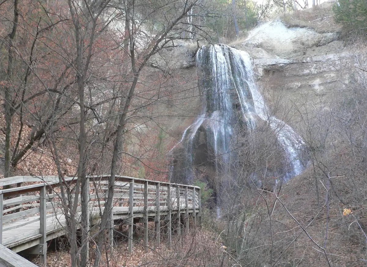 Smith Falls, a narrow waterfall spilling over a rock ledge into a wooded canyon.