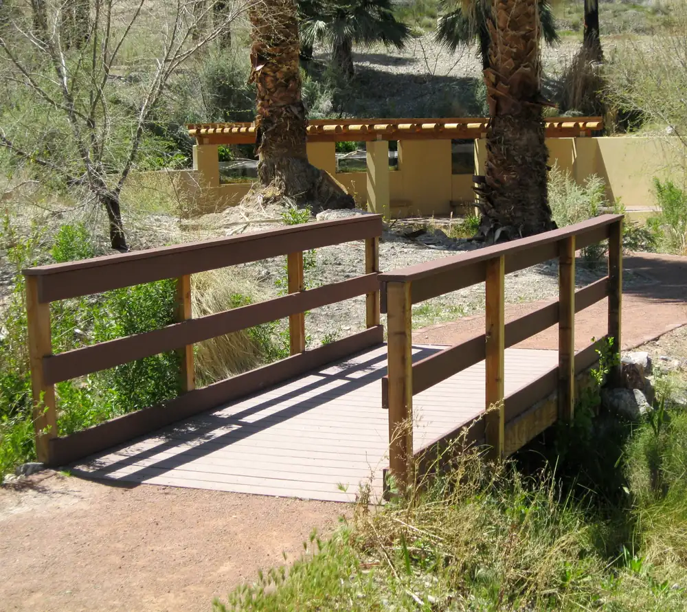 A trail and small footbridge crossing a spring-fed stream at Moapa Valley National Wildlife Refuge.